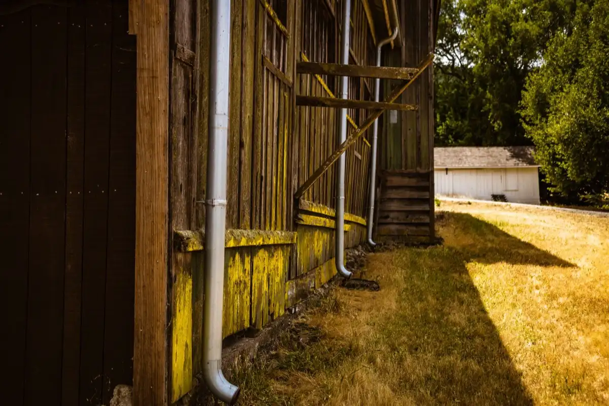 Roof edge, fascia and downspout on a house in Concord, CA, where drip edge carries runoff into the gutter